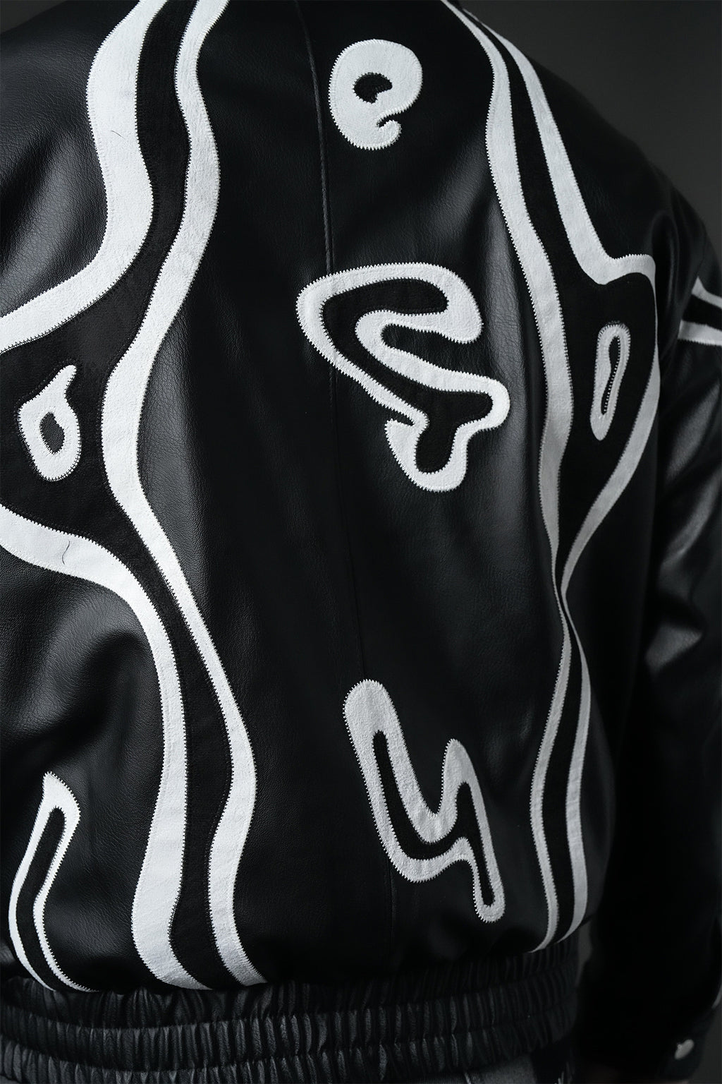 Blouson homme simili cuir noir oversize à appliqués abstraits noir et blanc, col chemise zippé