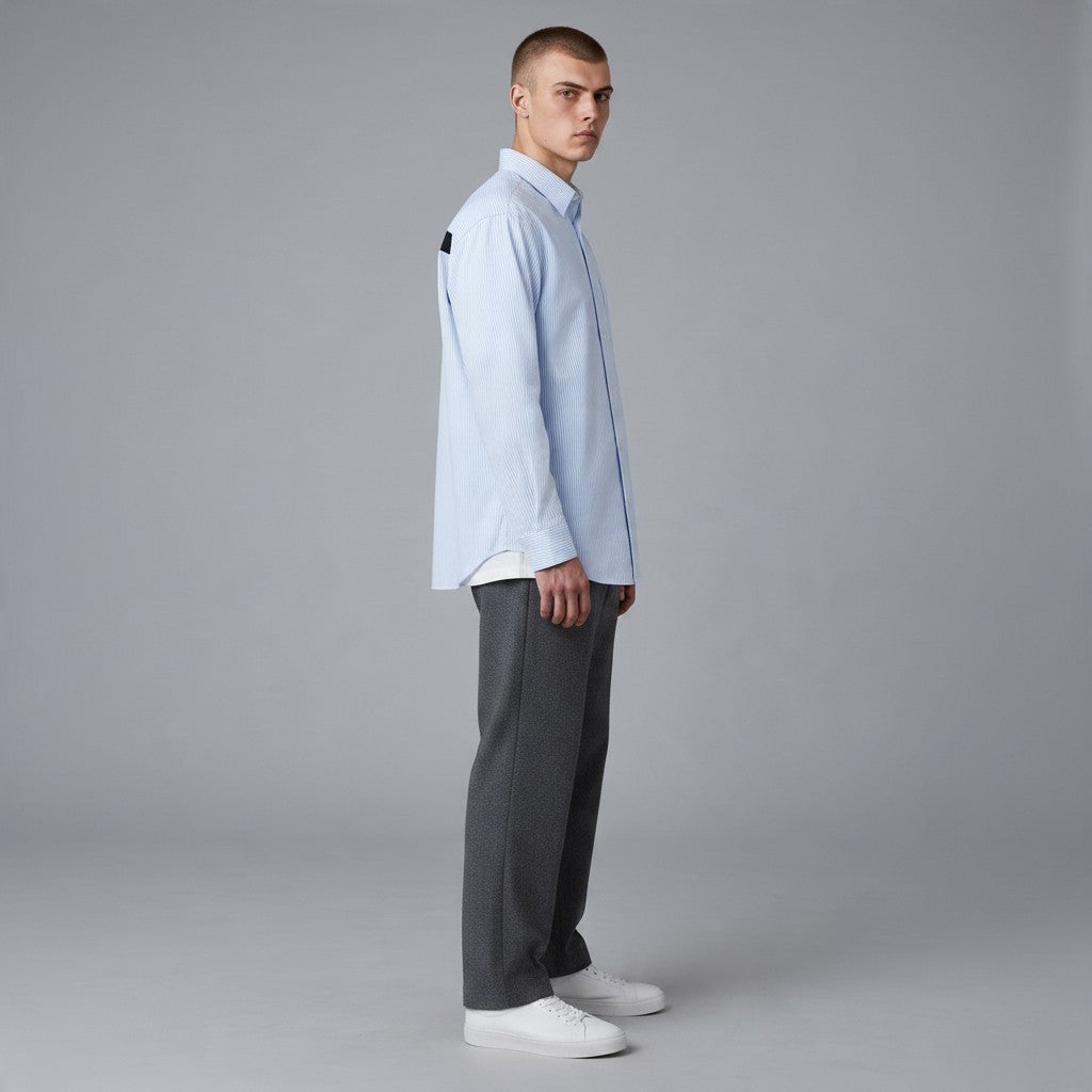 Homme portant une chemise bonhomme oversize à rayures bleu ciel avec imprimé ART de vivre au dos, vue de profil