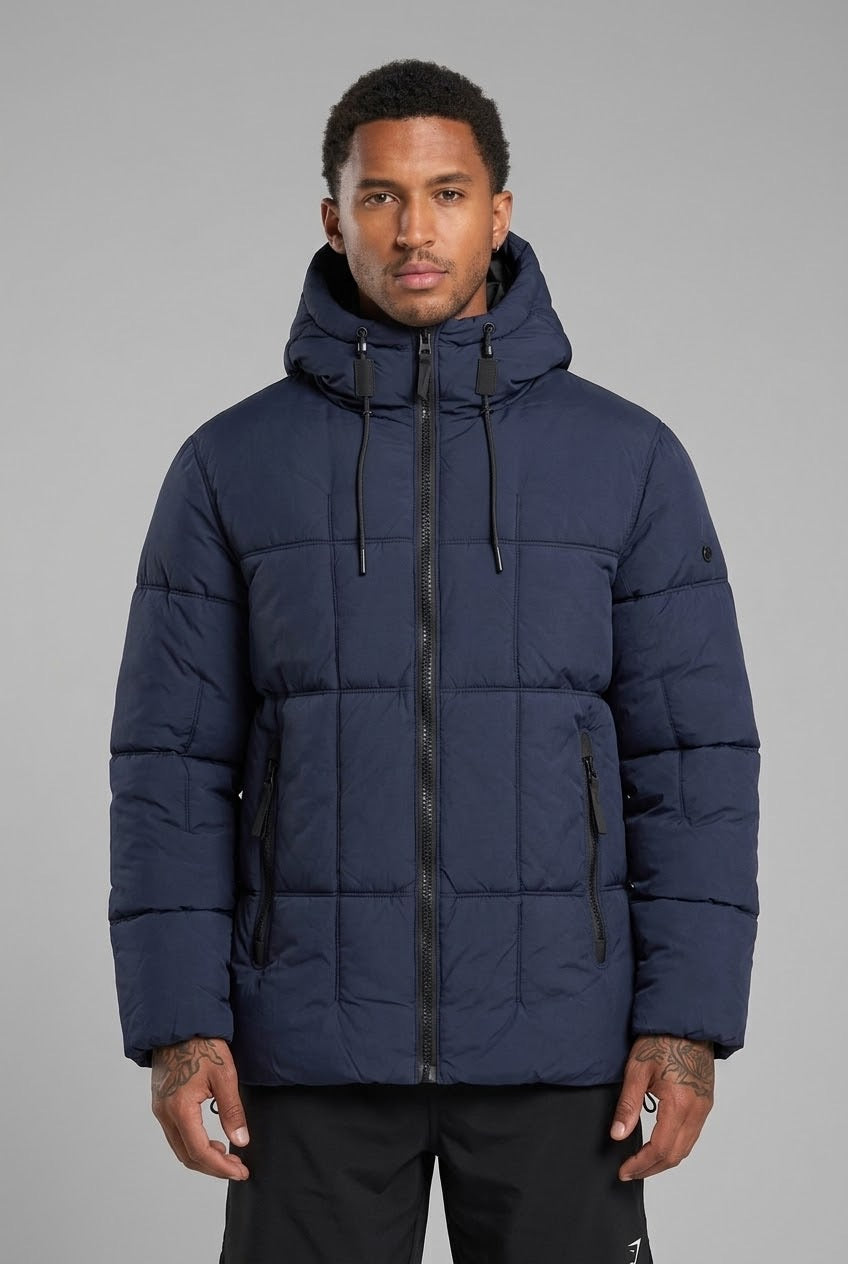 Homme portant une doudoune bleu marine bonhomme à capuche, matelassage carré et fermeture zippée en nylon