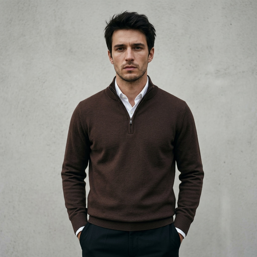 Homme portant un pull bonhomme marron à col camionneur demi-zip sur une chemise blanche, style élégant et épuré.