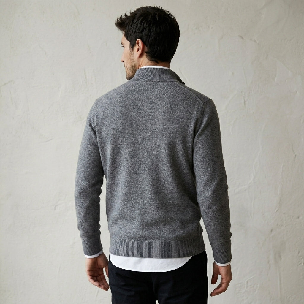 Homme portant un pull bonhomme gris à col camionneur demi-zip en maille fine, vue de dos sur fond texturé