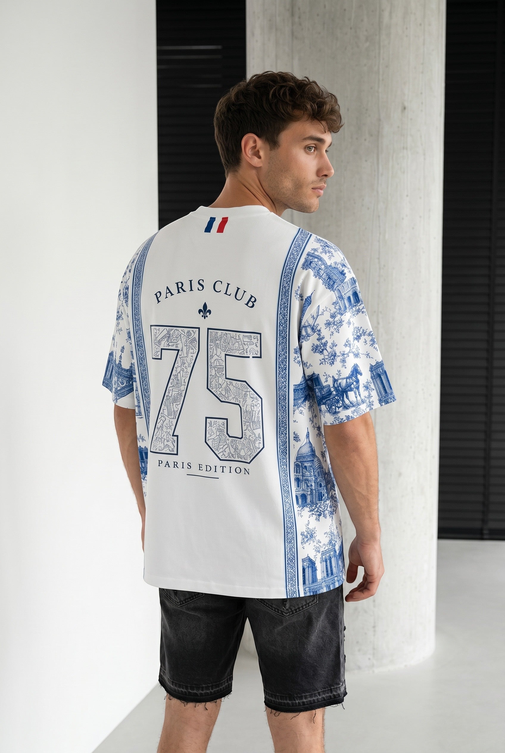Homme portant un t-shirt blanc bonhomme avec imprimé bleu style toile de Jouy et inscription Paris Club 75 au dos